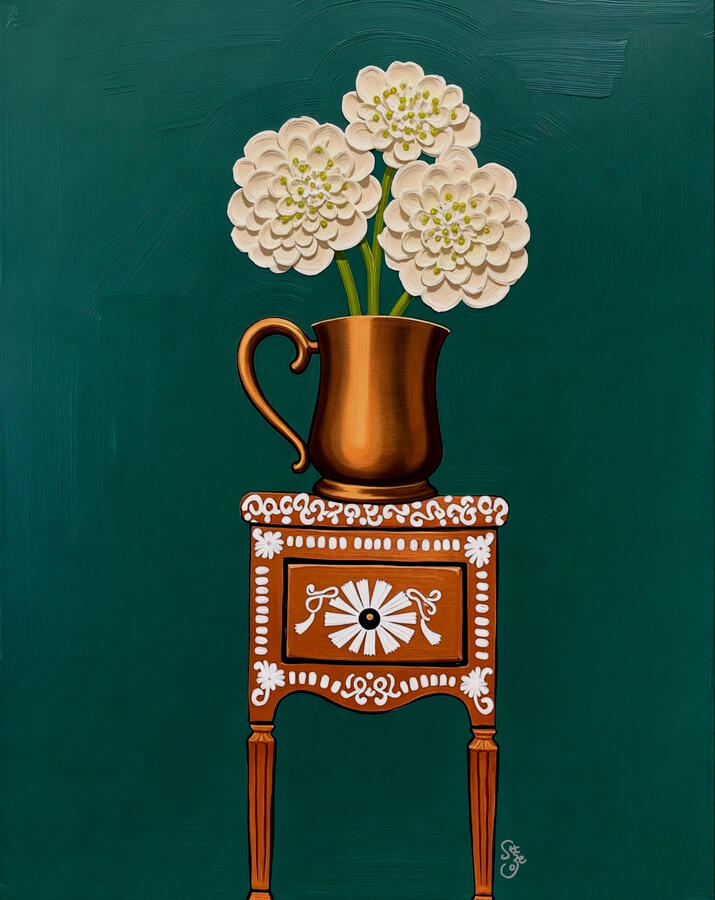 Cream hydrangea flowers in a matter of bronzy jar sitting atop a white patterned orange brown vintage inlaid cabinet. Deep emerald green background.