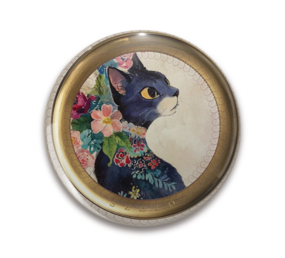 An ornate round pinback button close up, containing an illustration of a floral black cat painting with large golden eyes, surrounded by pink, blue, and cream flowers on a soft neutral background.