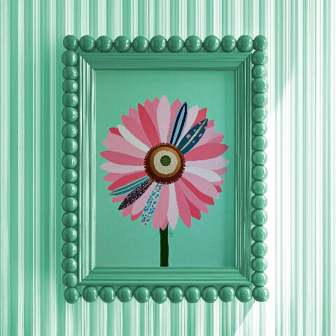 Framed mockup of an Acrylic art of a large stylized pink daisy with swirling dots and stripes patterns, vibrant layered bronzy core, surreal floral illustration. . Matching mint green bubble bead frame and matching minty striped wall.