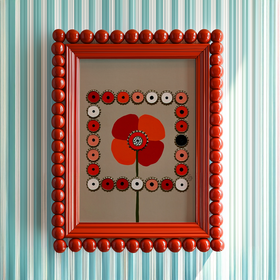 Artistic depiction of a red poppy flower surrounded by circular patterns on a beige background. Framed in read bubble bead on light blue striped wall.